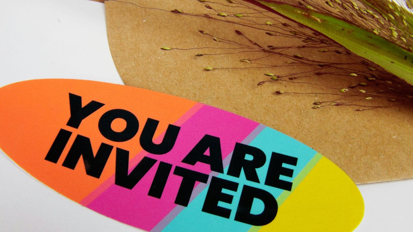 A colorful card with You Are Invited on it