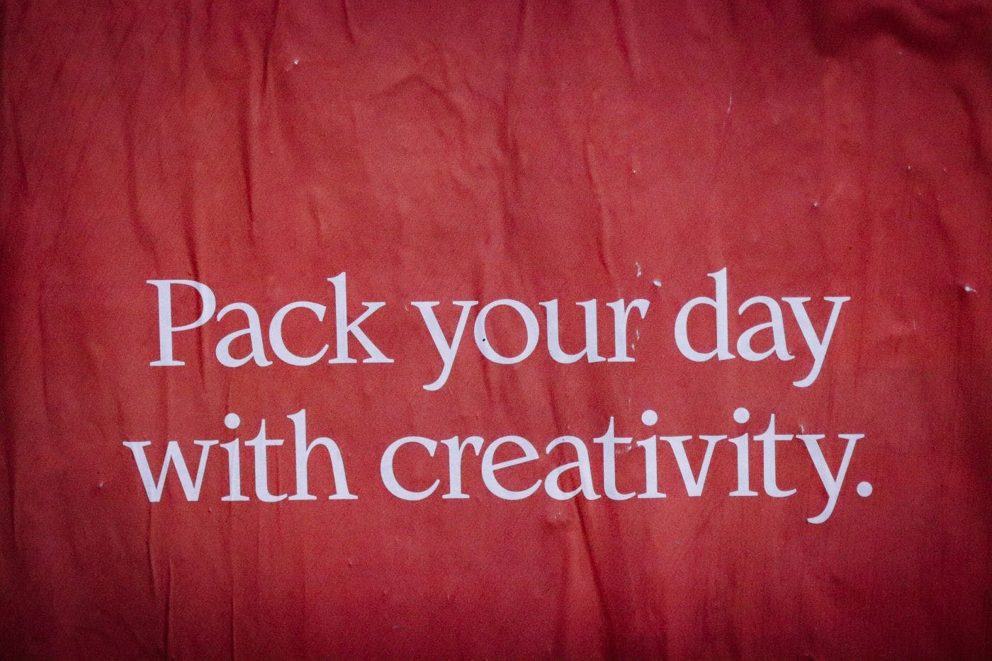 A red poster reading: Pack Your Day With Creativity