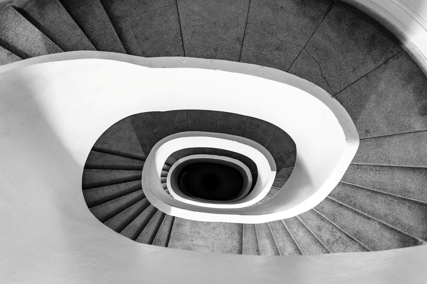 A black and white picture looking down on a spiral staircase