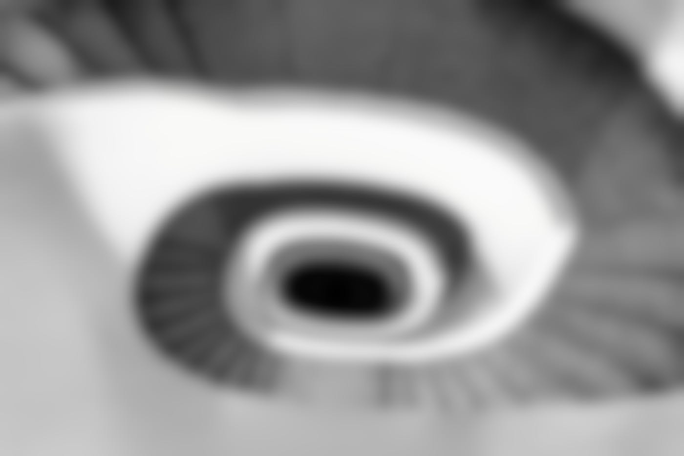 A black and white picture looking down on a spiral staircase