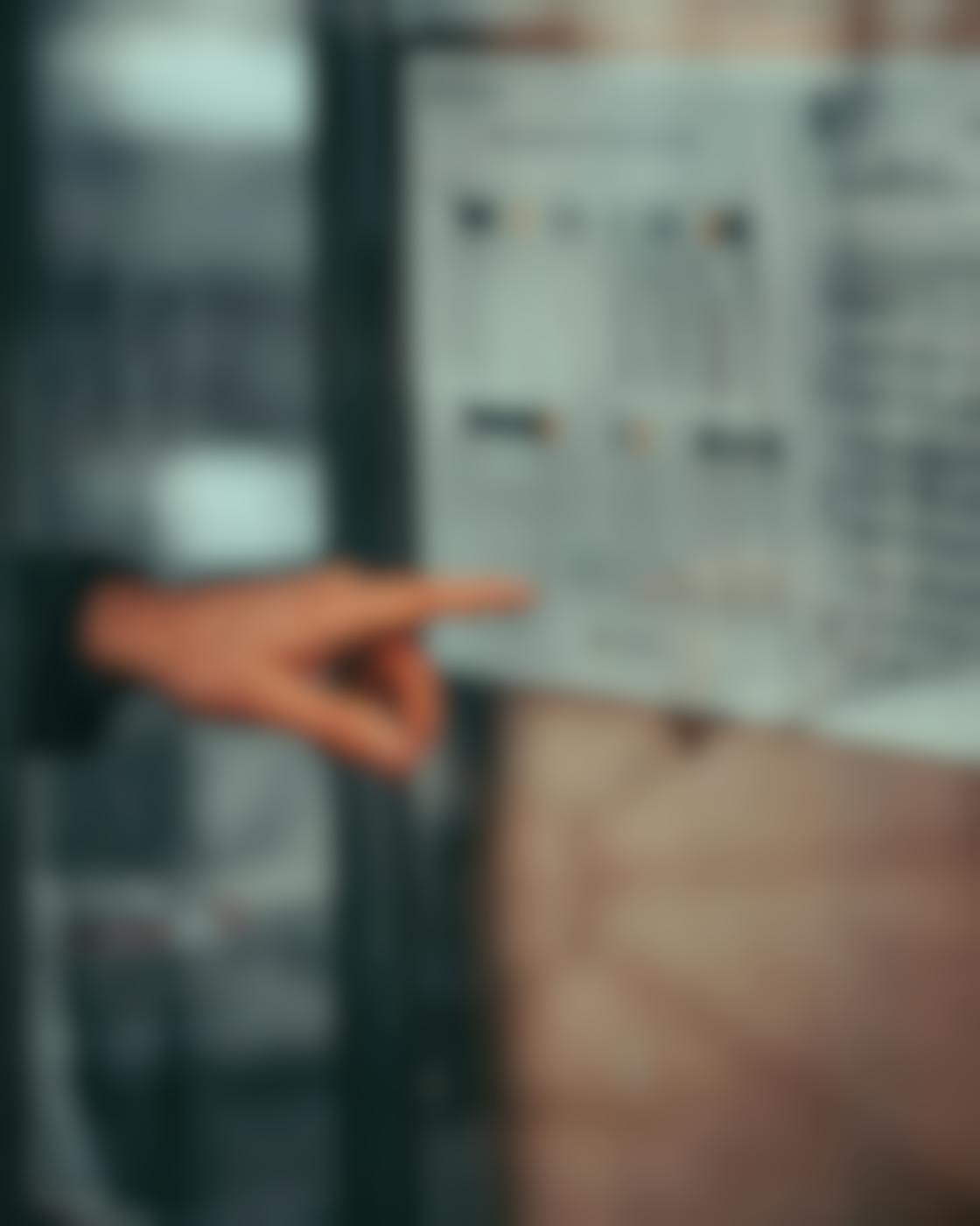 A man's hand pointing at a bus schedule