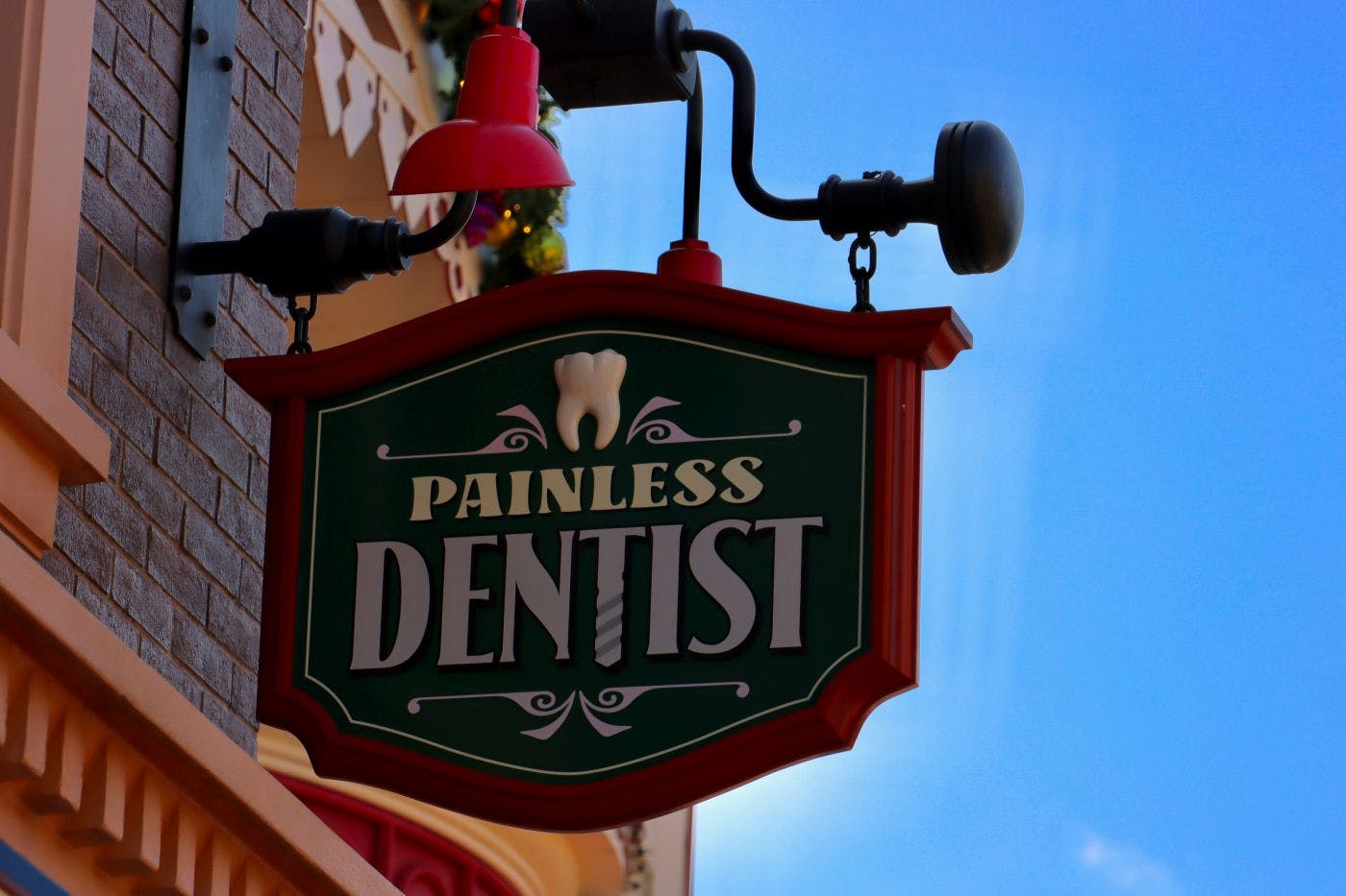 A sign on a building with a Tooth and Painless Dentist