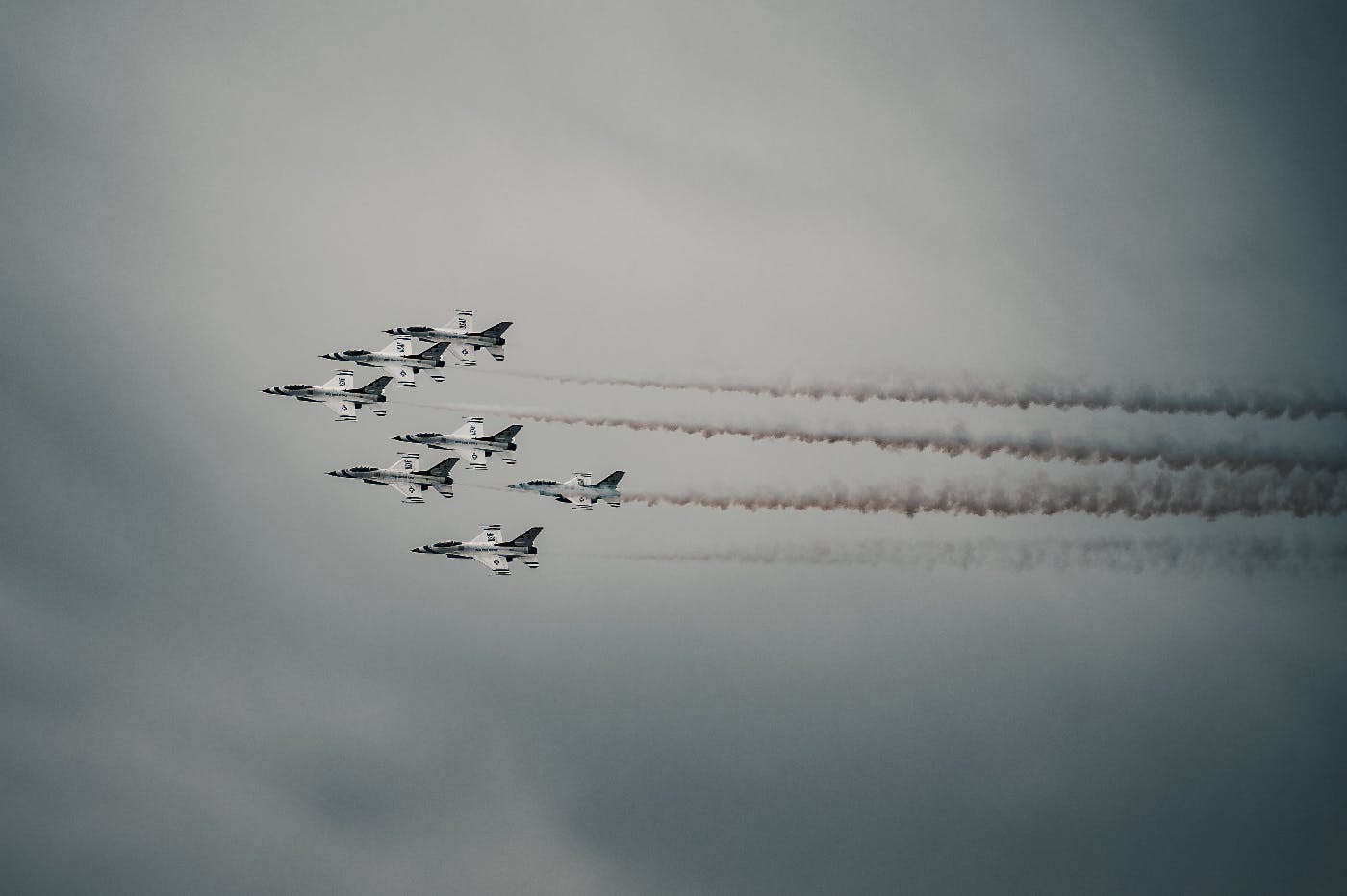 Eight fighter jets, in formation against a grey sky