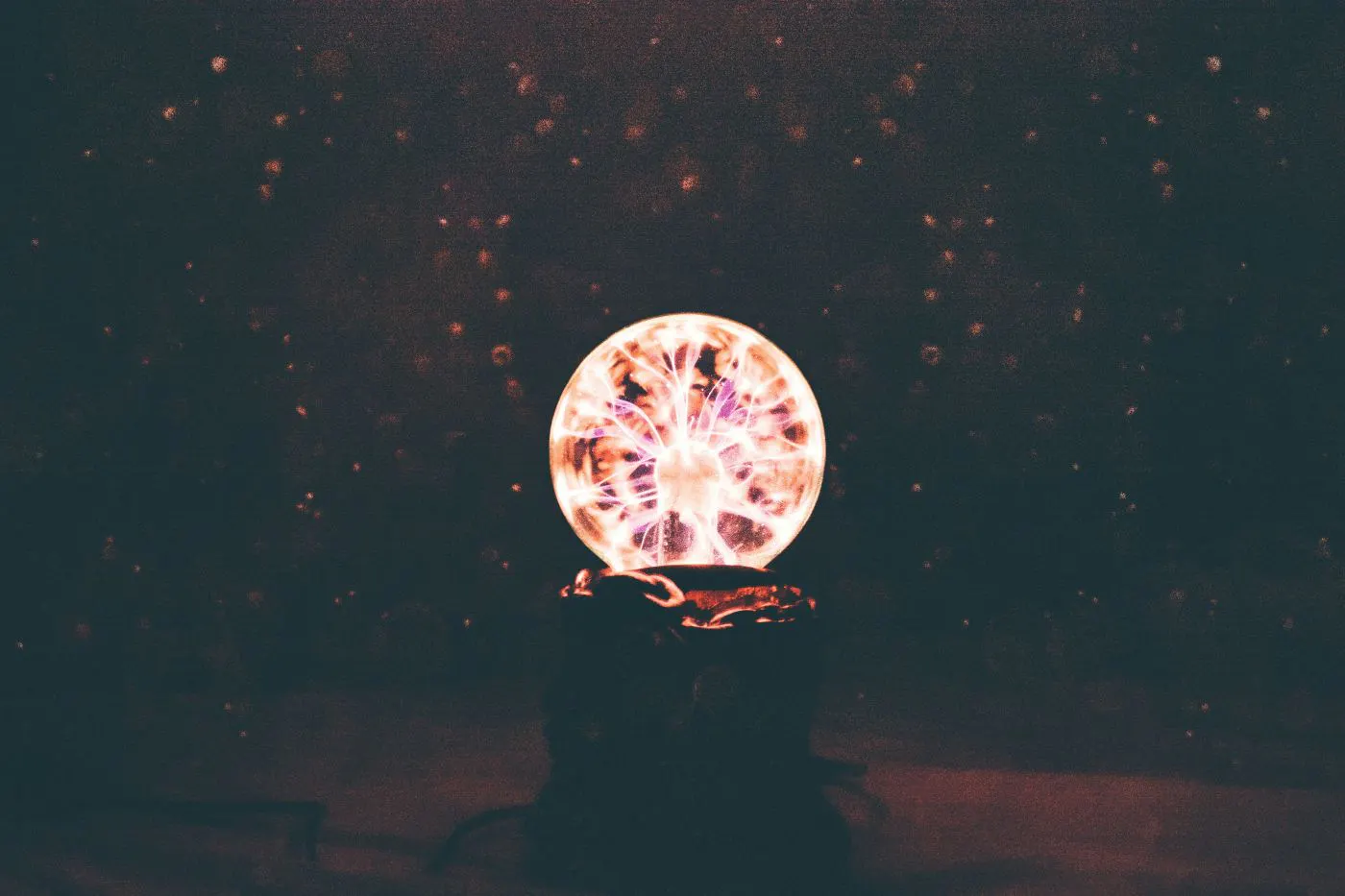 A multi colored plasma ball in a dimly lit room
