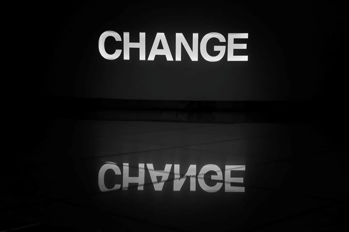 The word change on a wall reflected in a polished floor