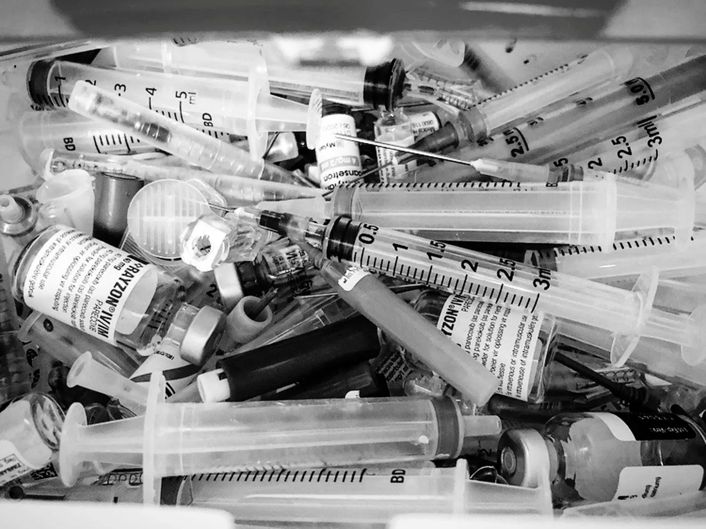 Black and white image of syringes, pipes, vials