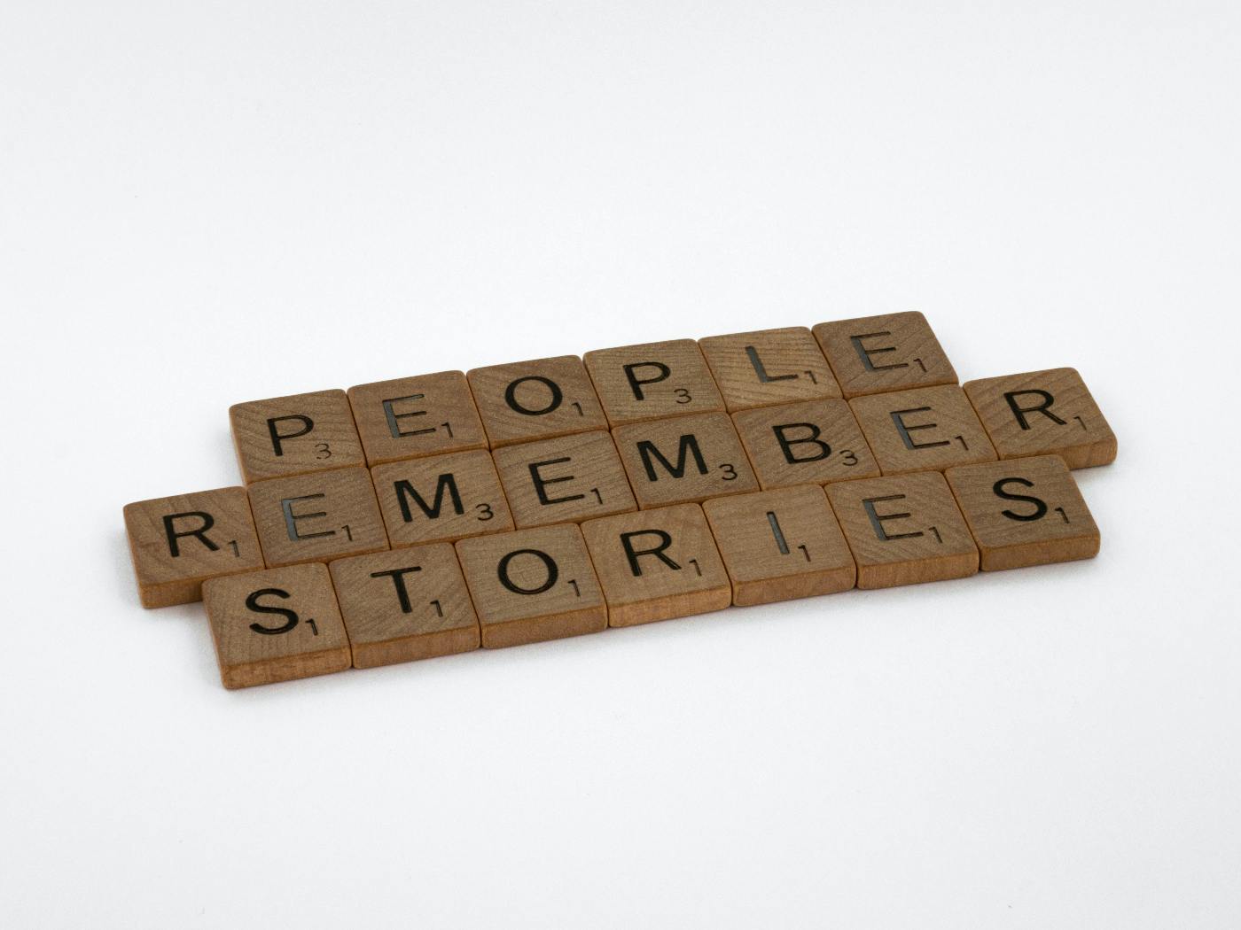 Scrabble Tiles spelling out People Remember Stories