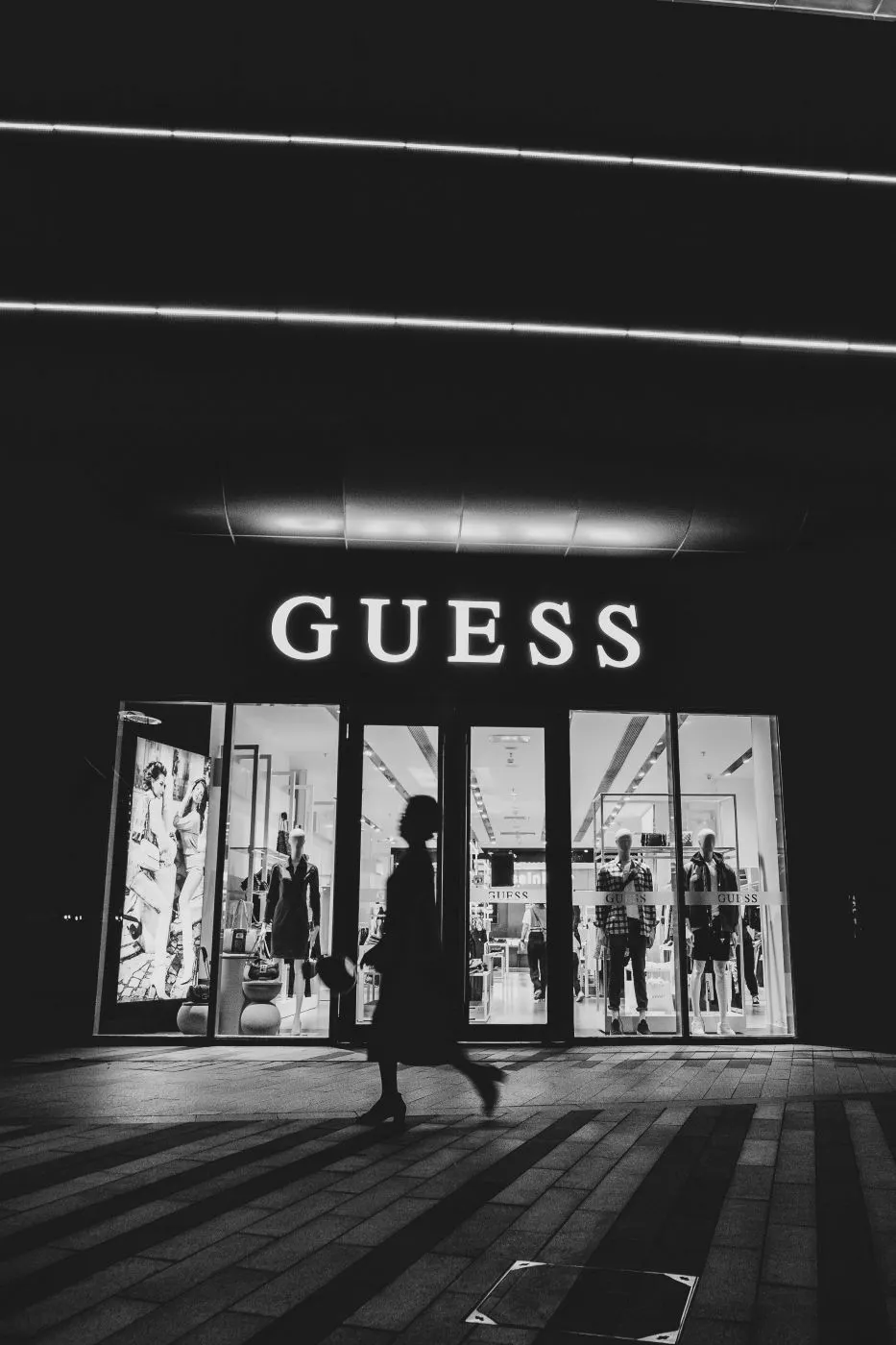 Black and white image of the front of a Guess clothing store