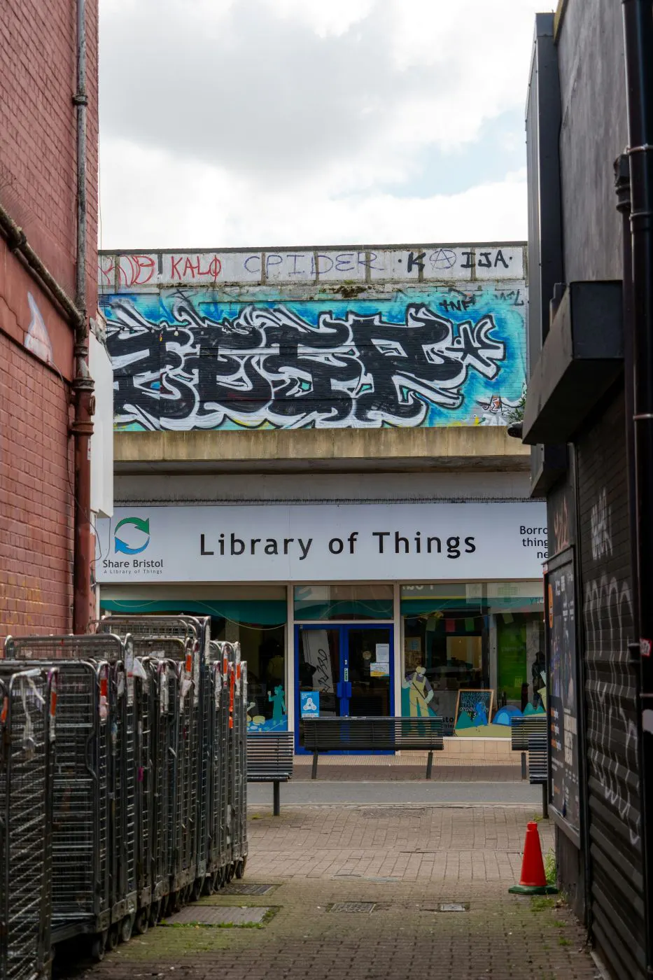 A shot through an alley of a sign reading Library of Things