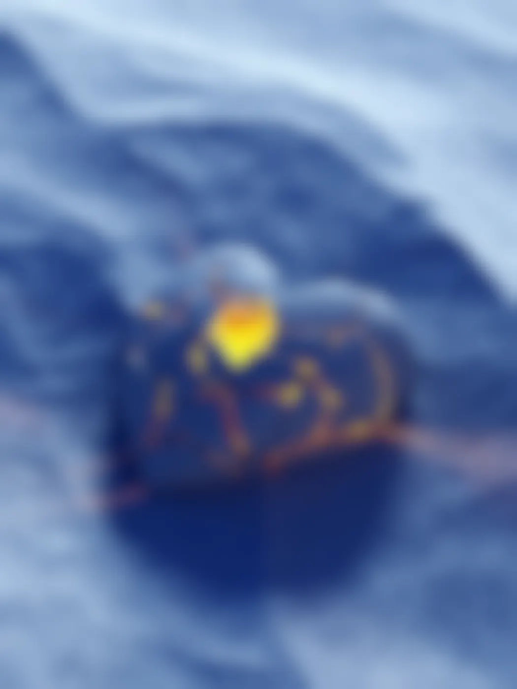 A blue heat shaped stone, cracked with yellow light inside