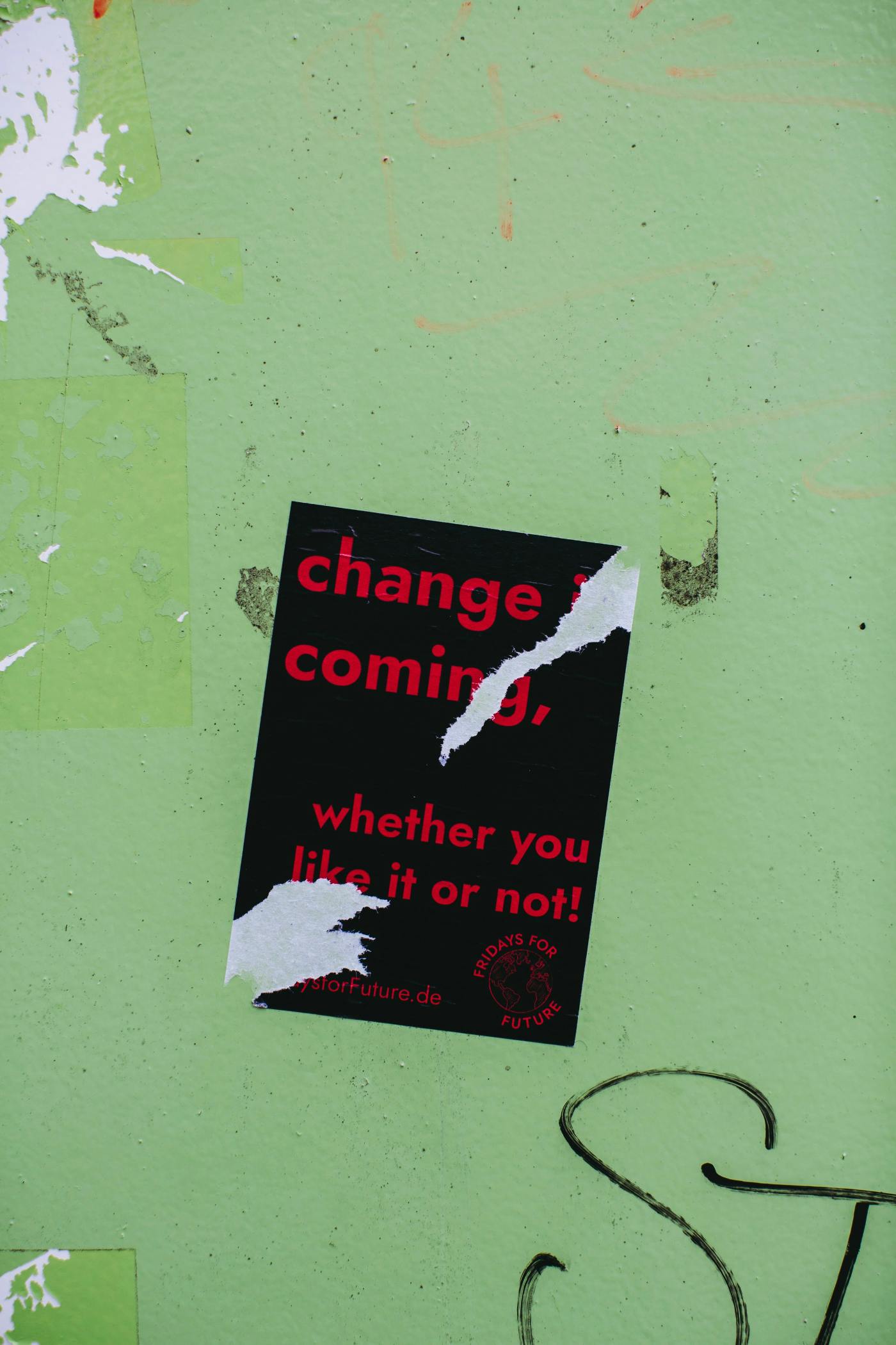 A torn poster reading; Change is coming, whether you like it or not.