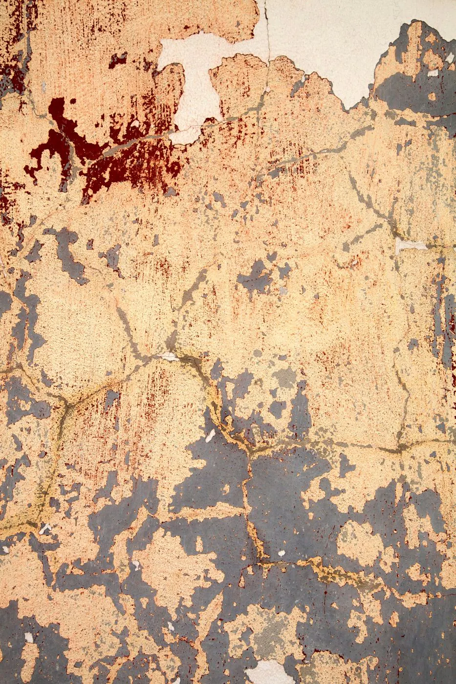 A wall covered in cracks and peeling paint