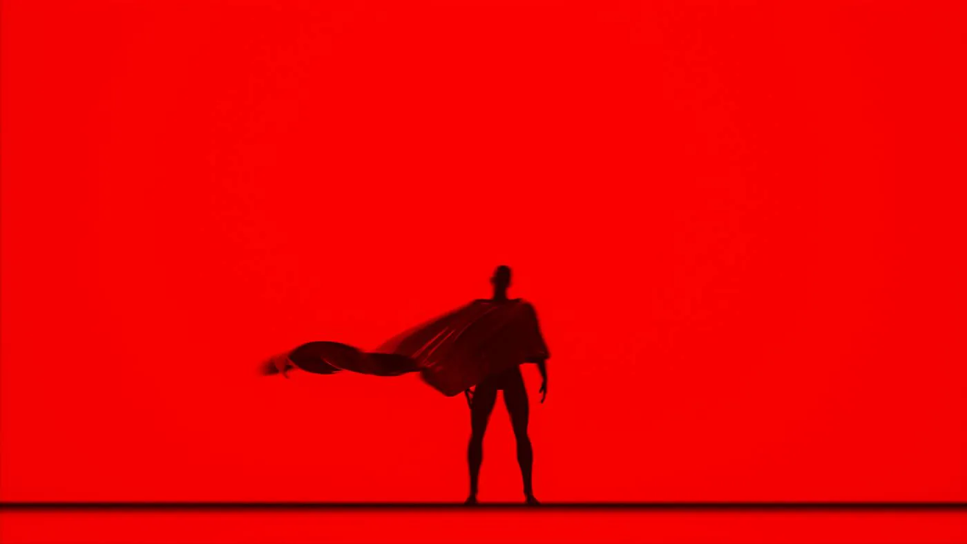 Silhouette of Superman, cape flowing against a red backdrop