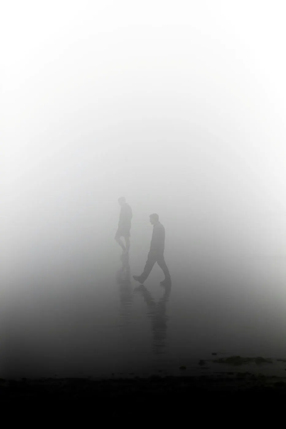 Two people walking in a heavy fog