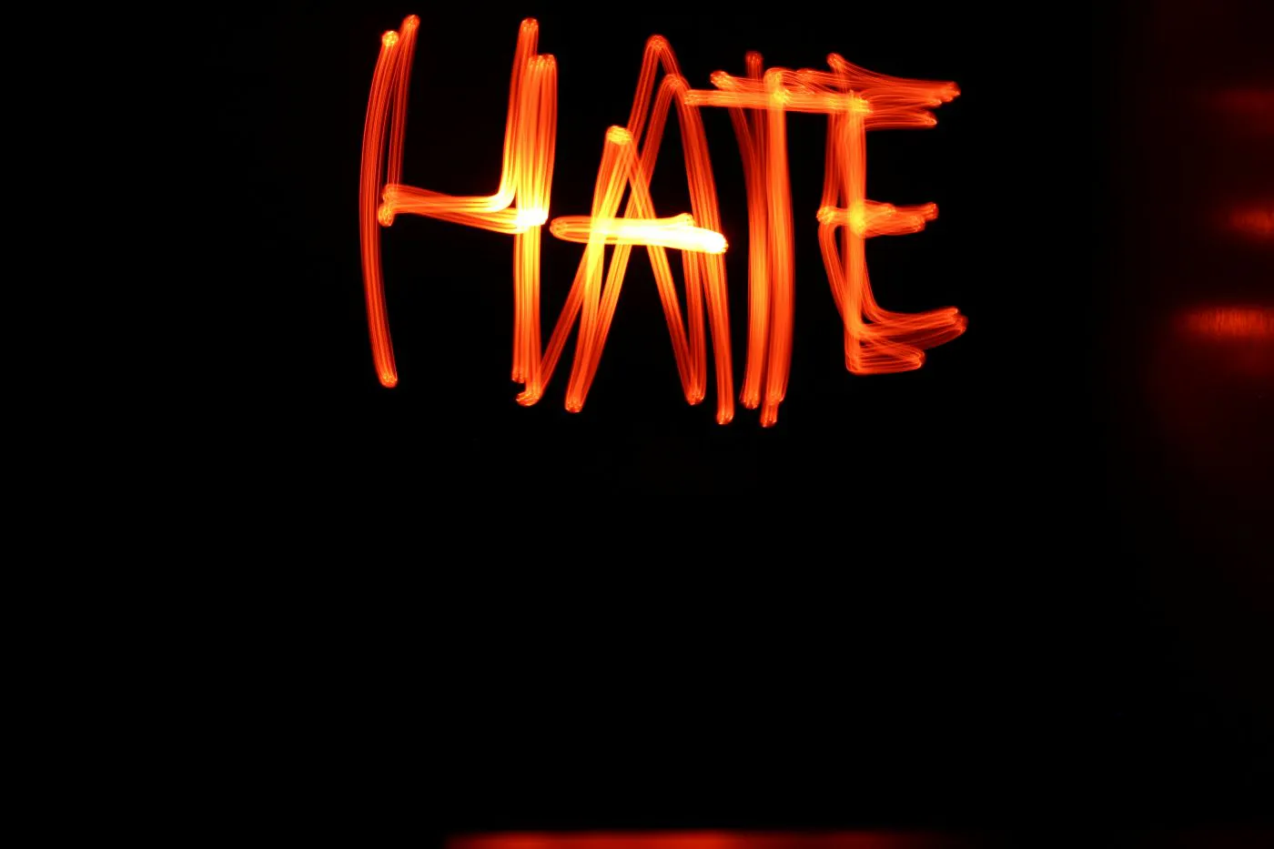 Red neon sign reading HATE