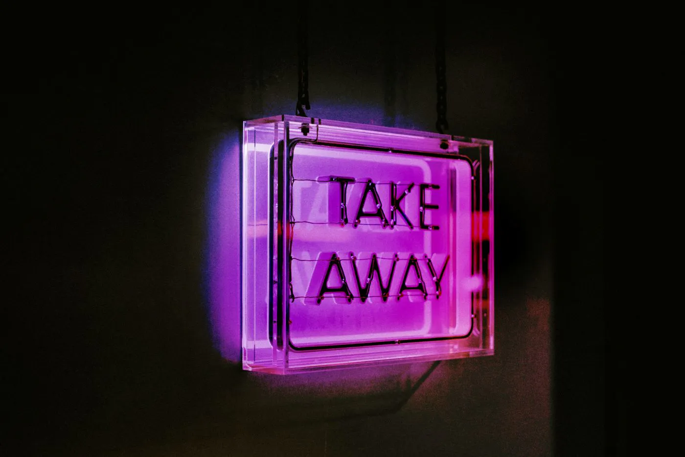 A purple neon sign reading Take Away