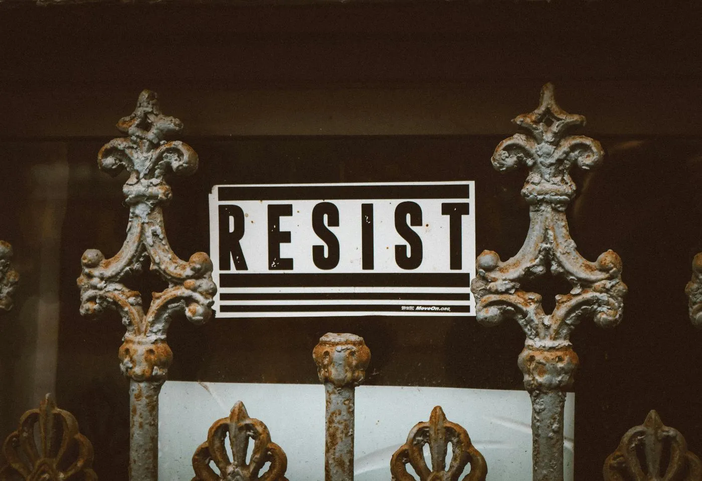 A wrought iron fence with the word resist over it