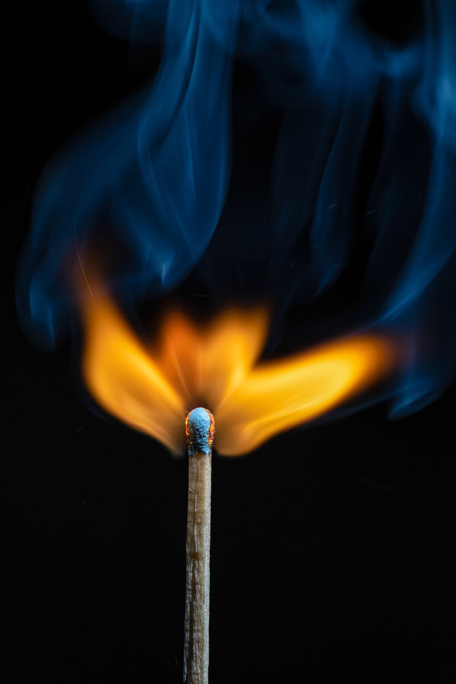 A lit match with yellow and blue flame