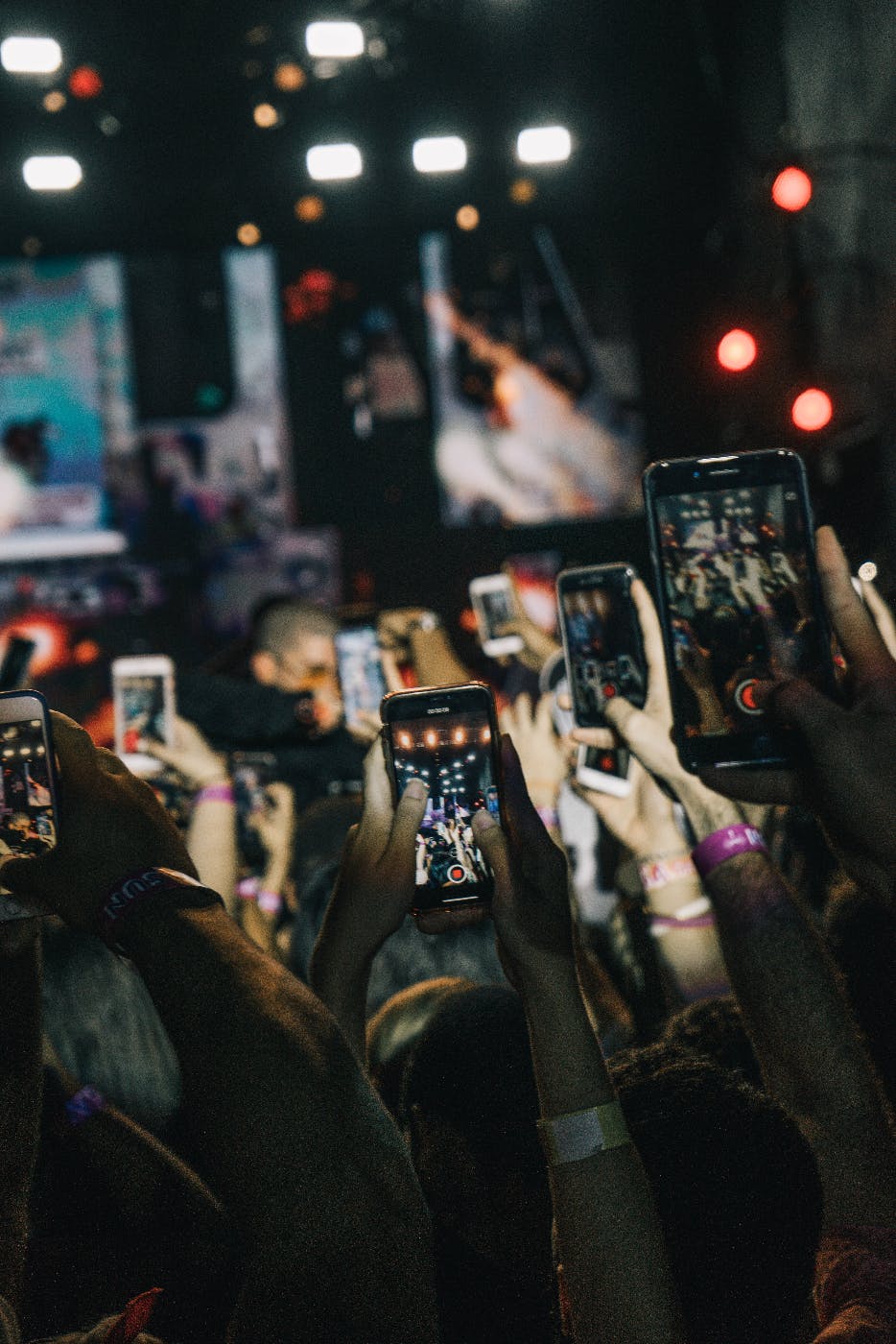 Hundreds of people raising their smartphones up to take a picture