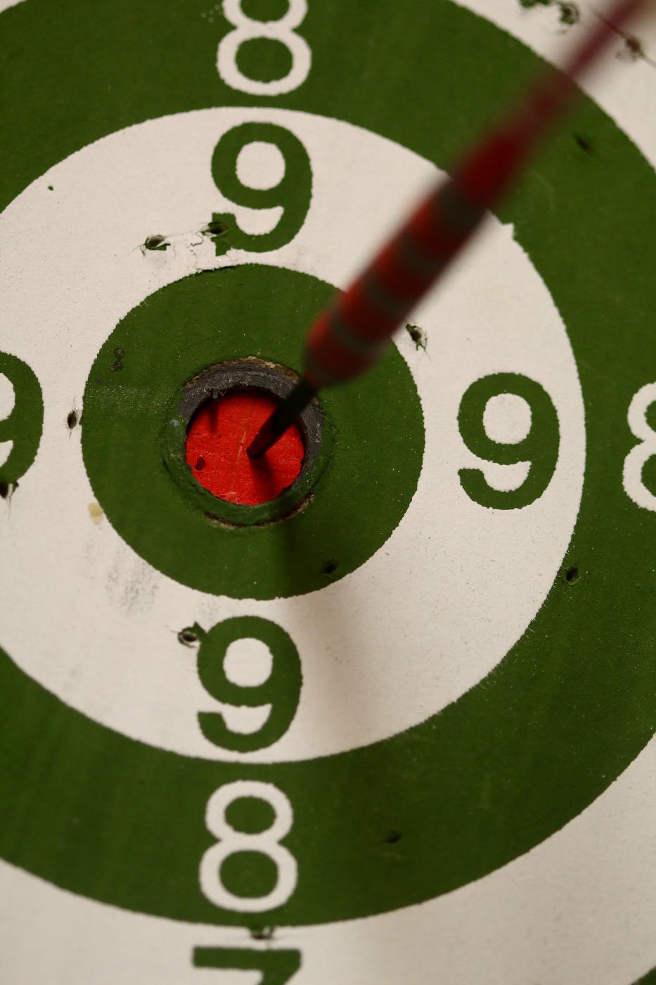 Close up on a dart board with a dart in the bullseye