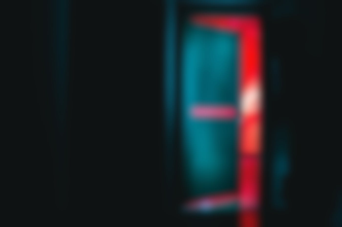 a dark hallway and a door opening into red