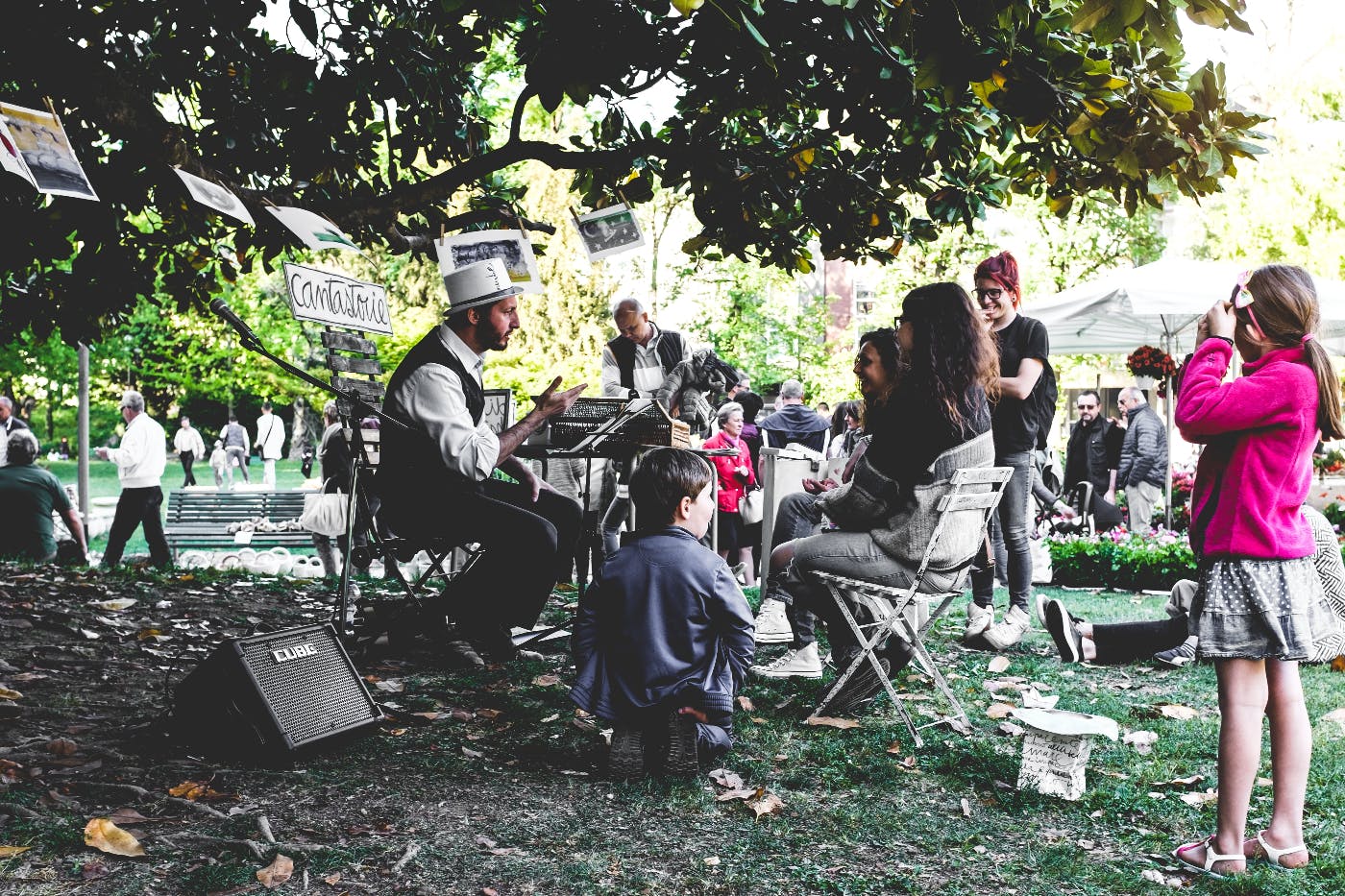 a crowd listening to a storyteller in a white top hat