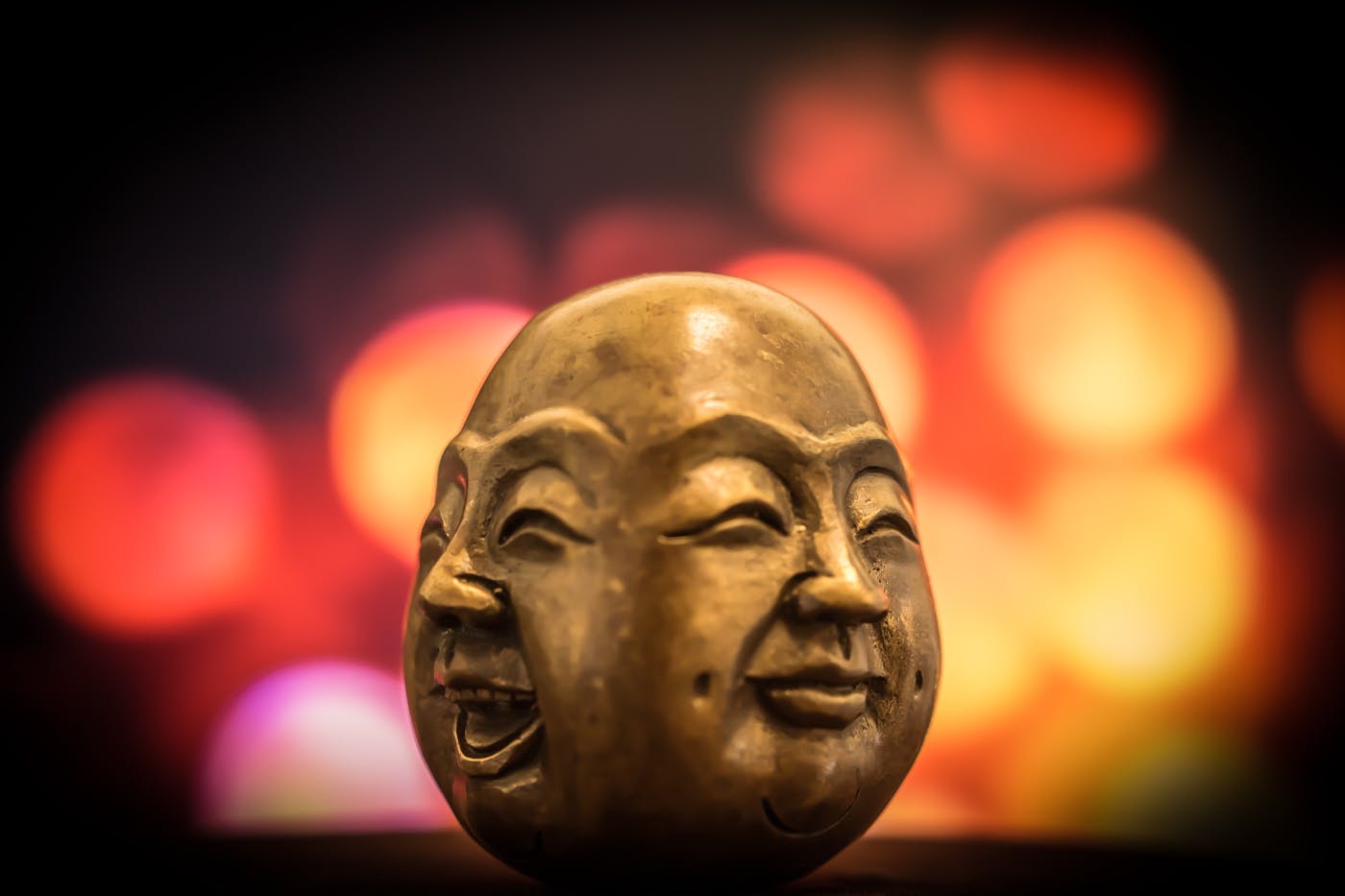 a small sculpture of a two sided head of Buddha