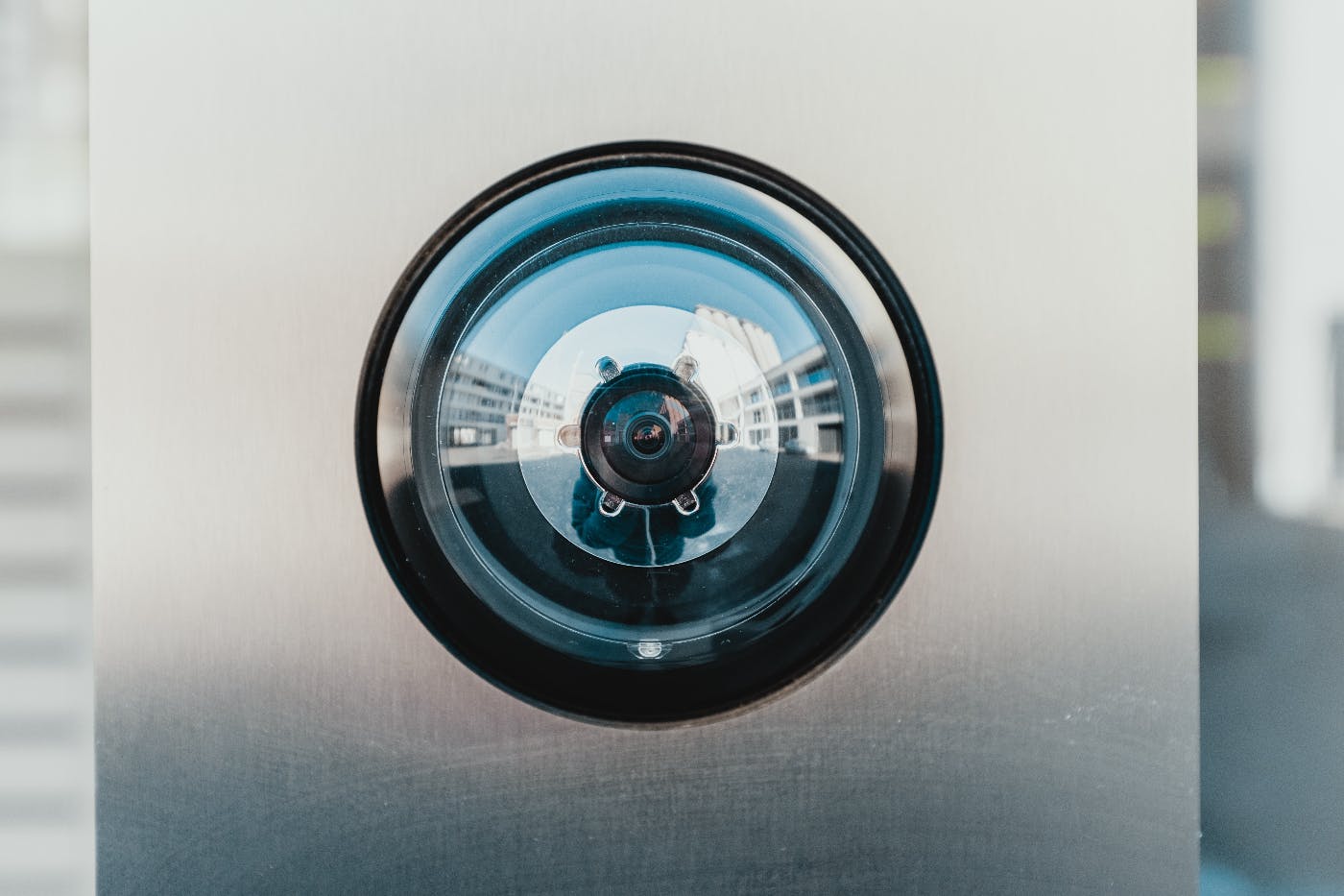 close up of a doorbell camera with the refelction of the photographer in it