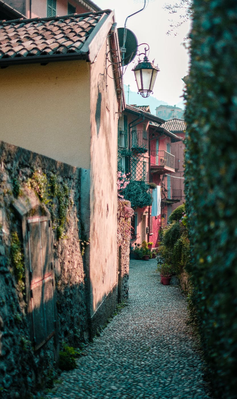 a cobblestone street in a tiny village with colorful houses