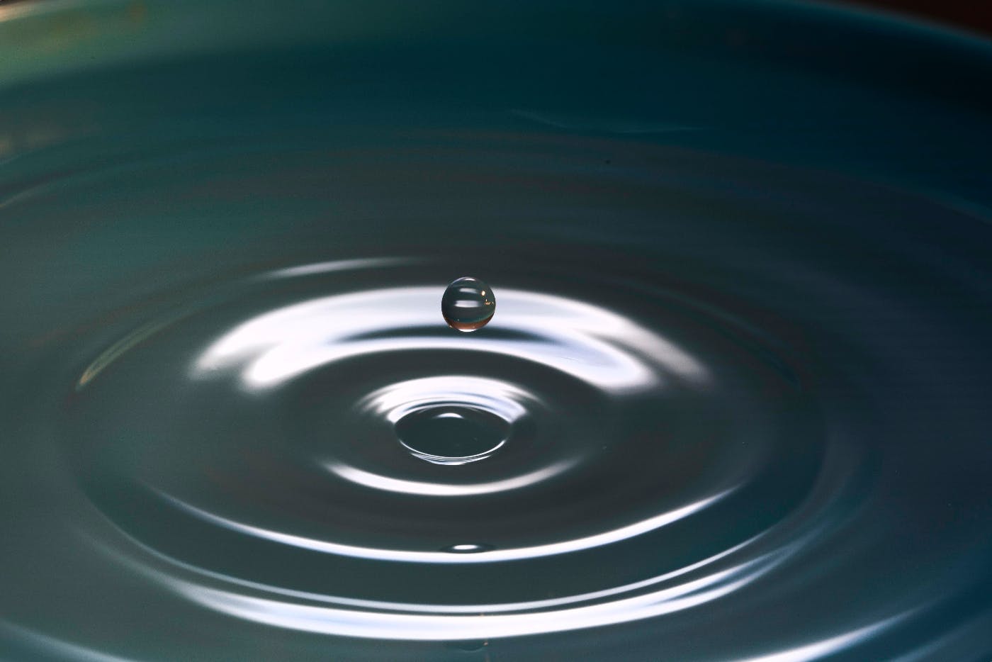 An orb of water above a rippled pool