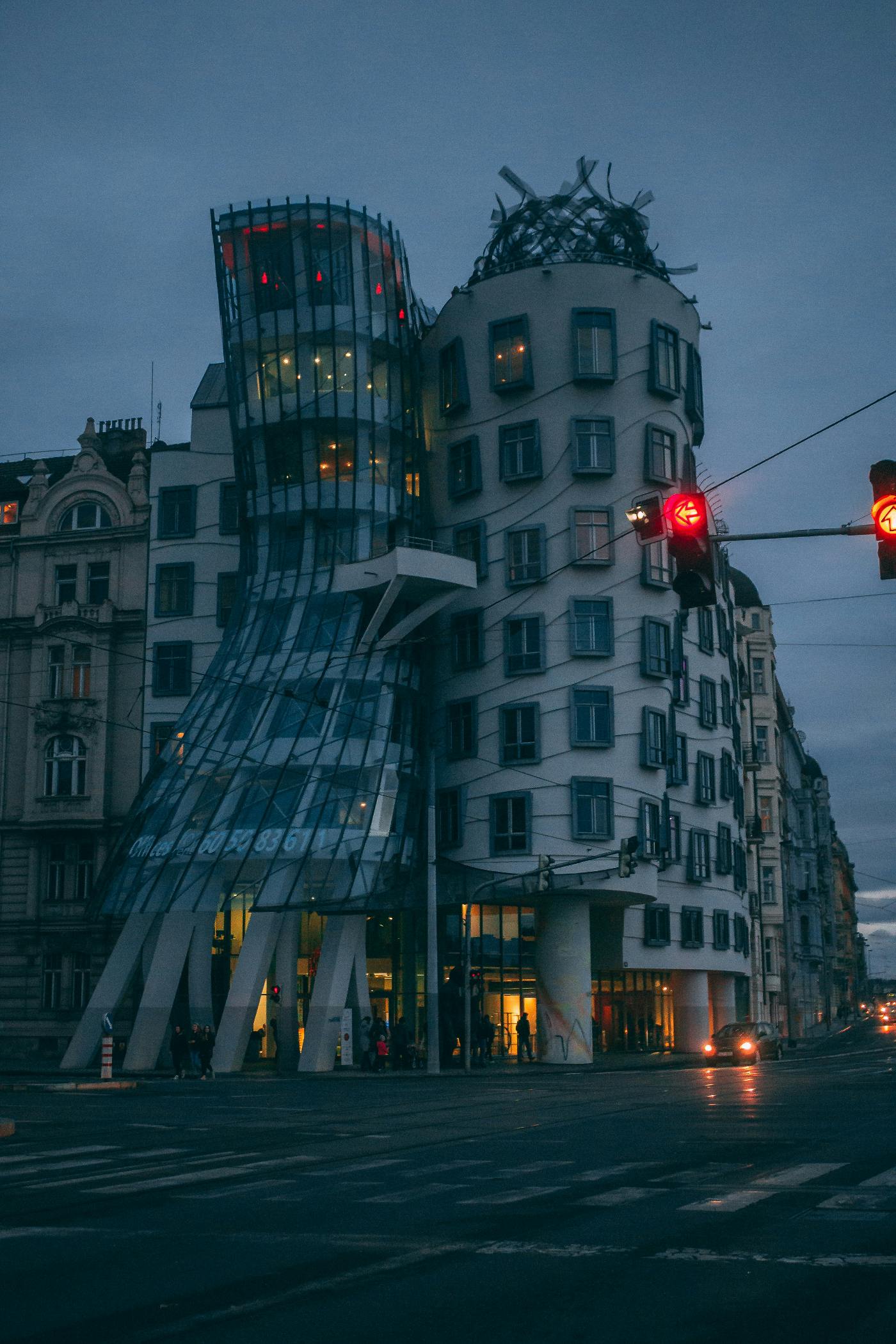 A building with architecture that makes it look like it is bending and falling.