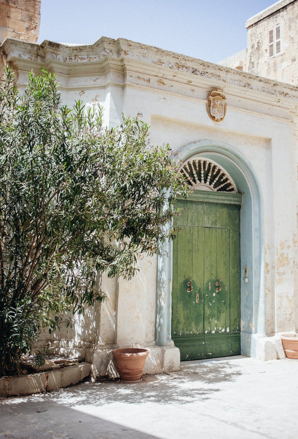 Green double doors in a marble arch doorway