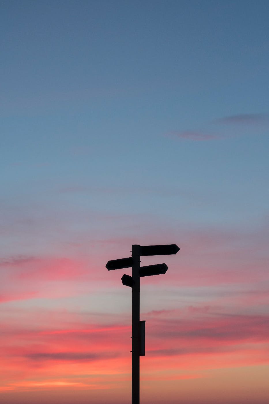 A road sign with 4 arrows in silhouette