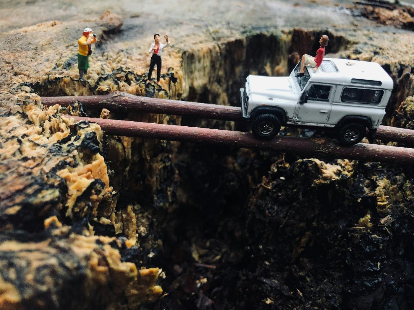 a jeep going over a canyon on logs in mini