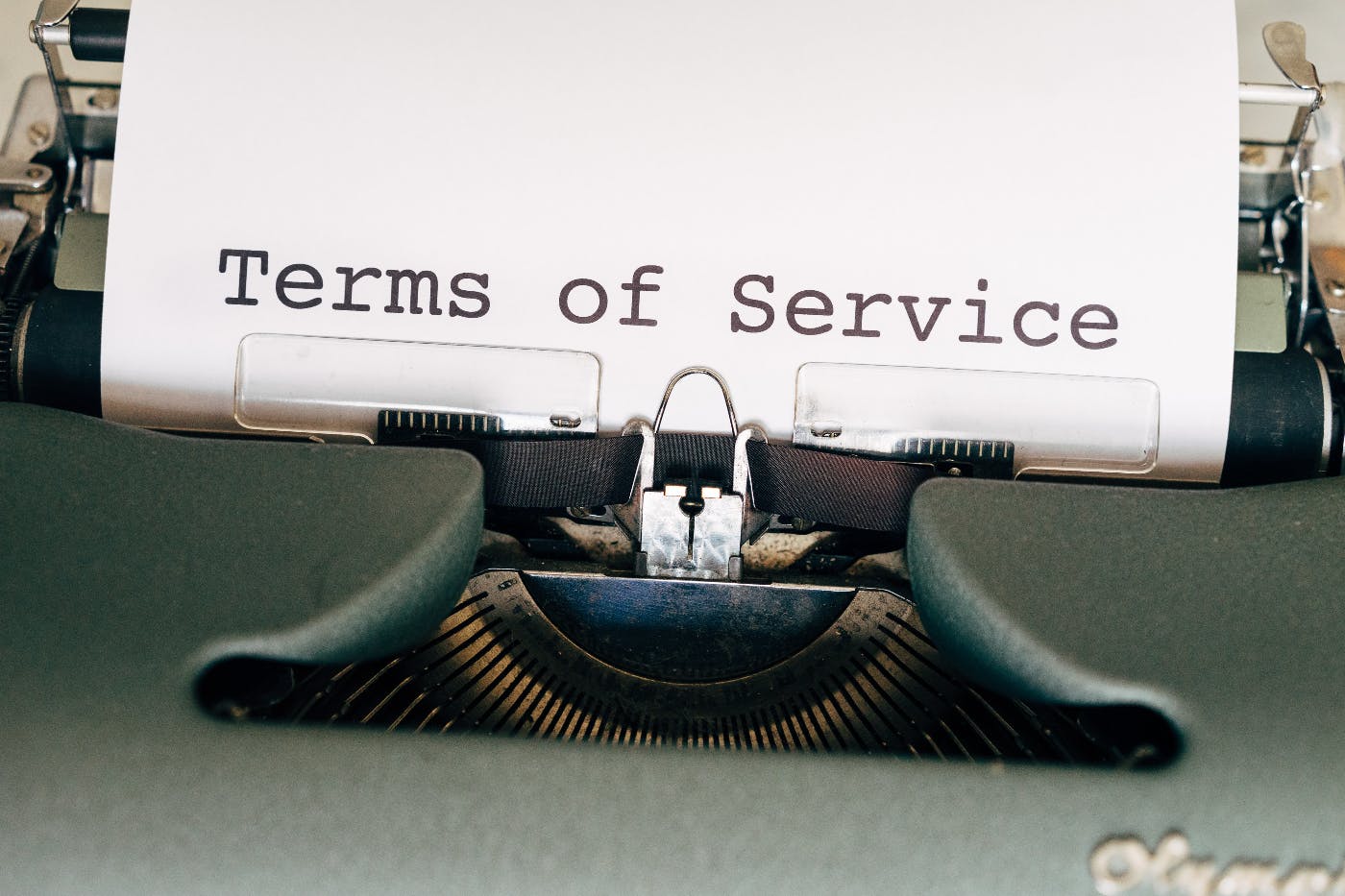 A typewriter with a sheet of paper in it displaying the words Terms of Service