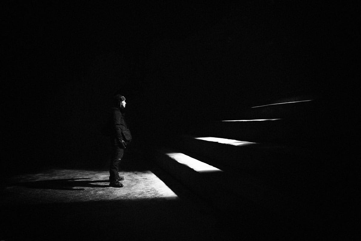 man at the bottom of dark staircasee