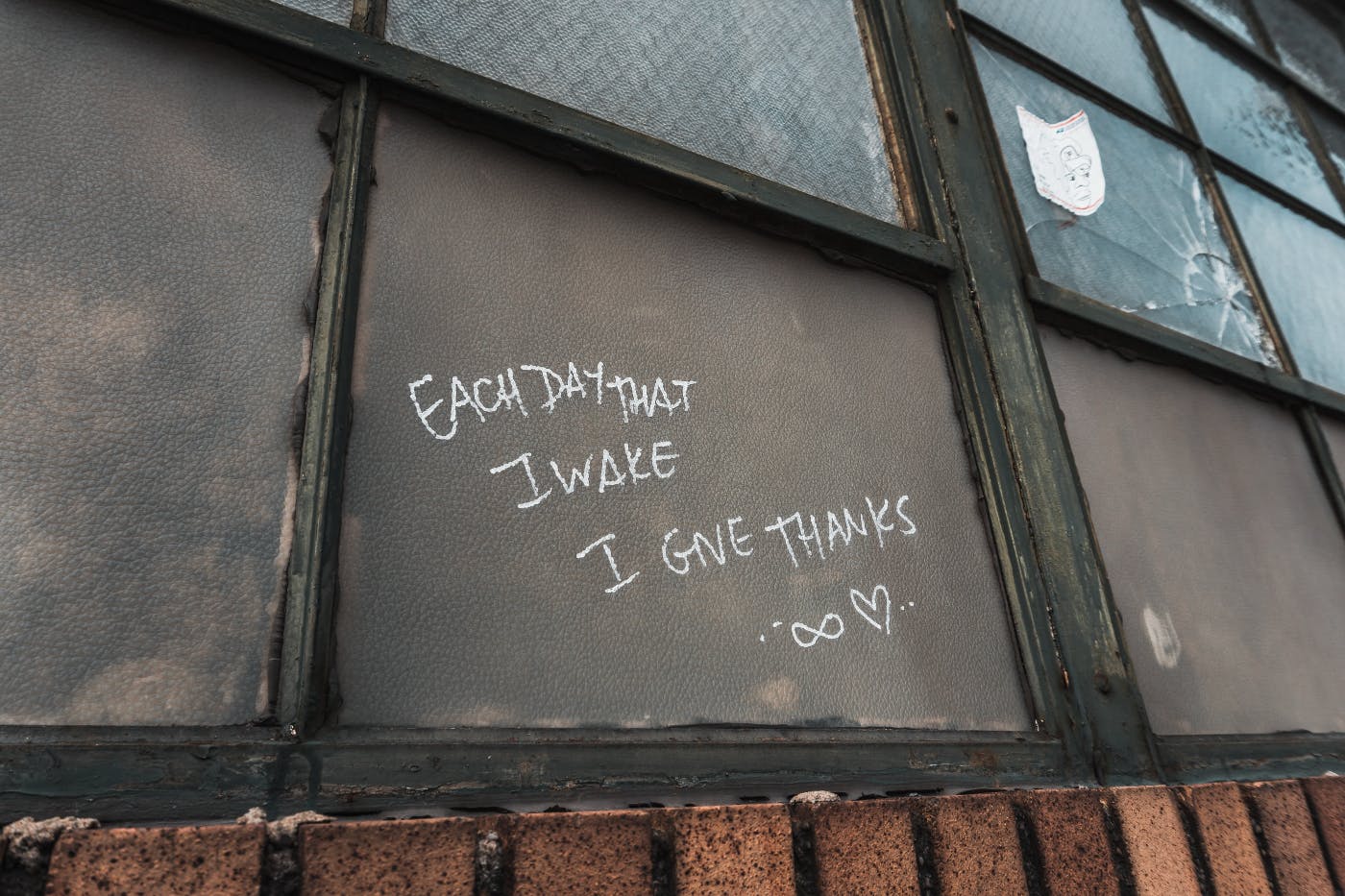 Writing on a window that reads: each day I wake up I give thanks