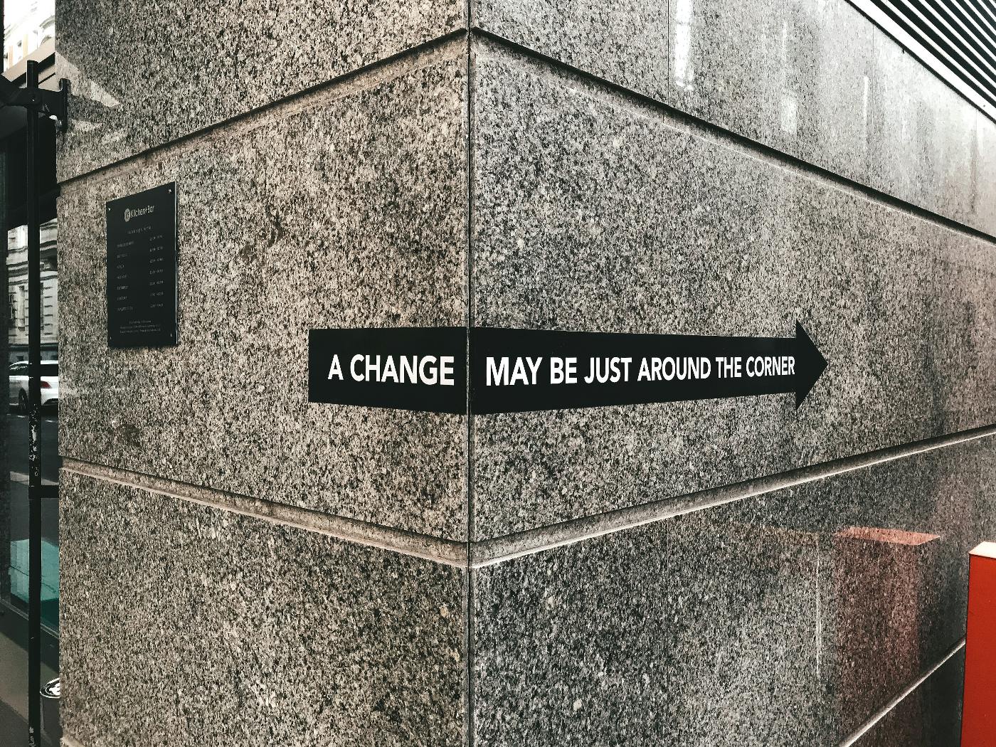 a banner wrapped around the corner of a building reading A change may be just around the corner