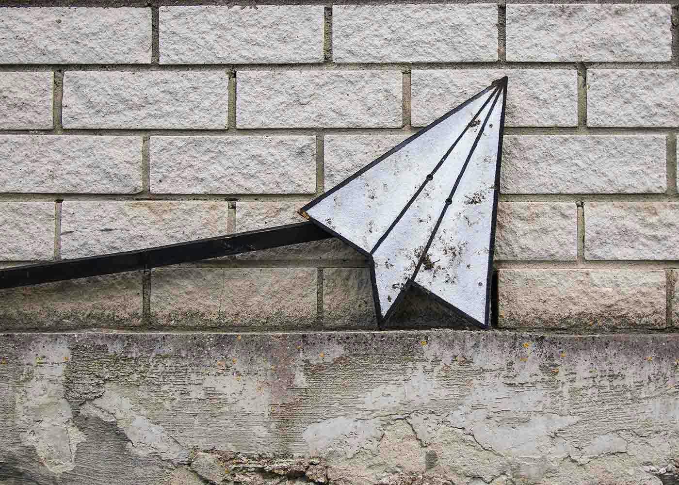 A mail airplane leaning against a brick wall