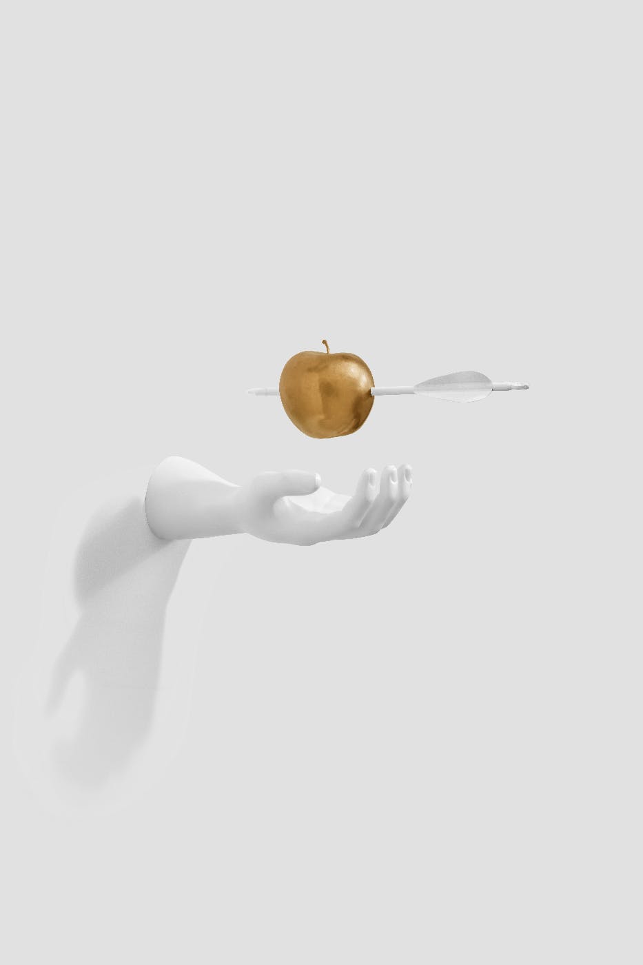 A white plaster had sticking out of a wall with a golden apple with an arrow through it hovering above it.