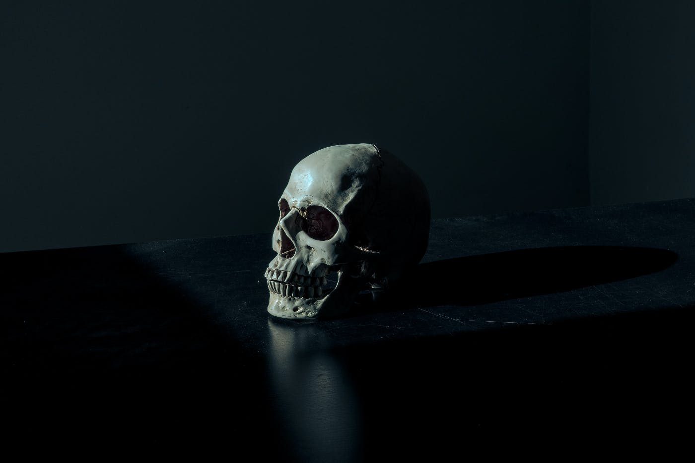 A human skull sitting on a black desk