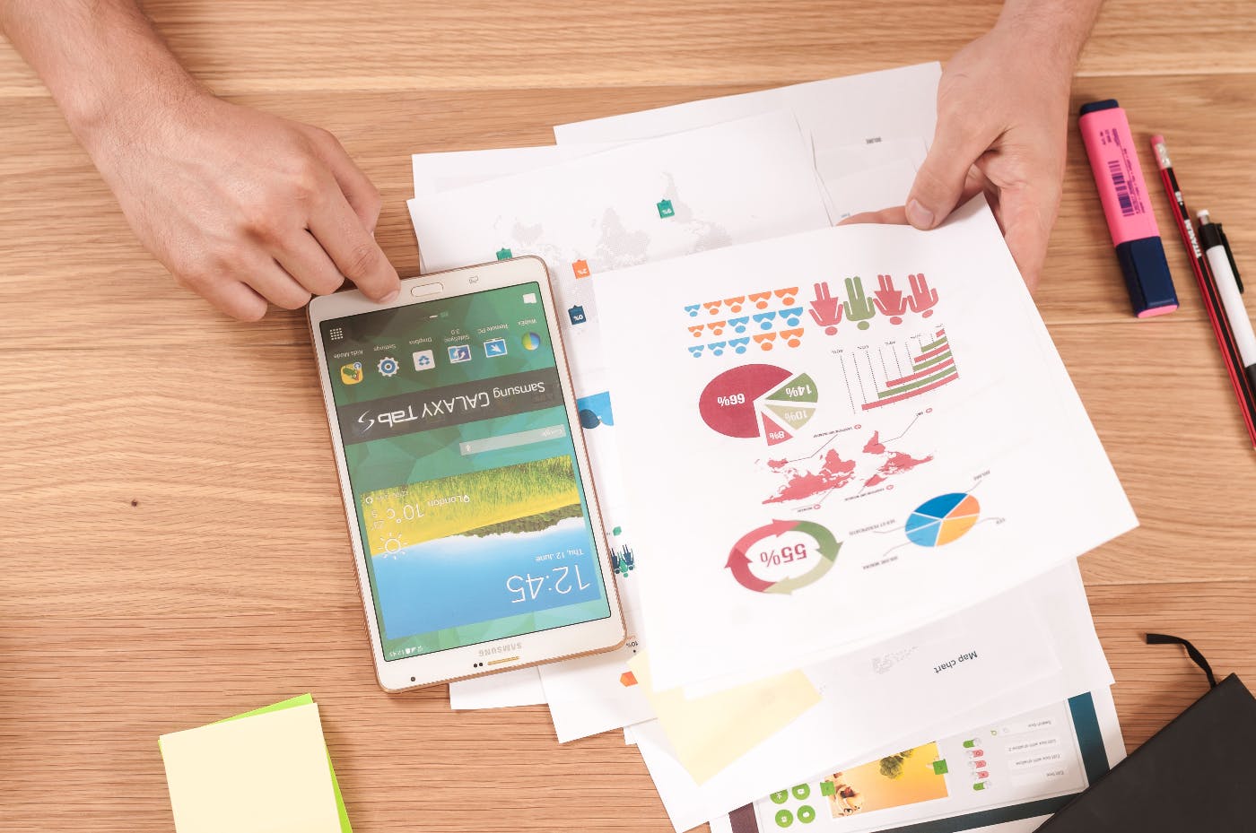 colorful charts & graphs, a cell phone, pencils and a highlighter on a table