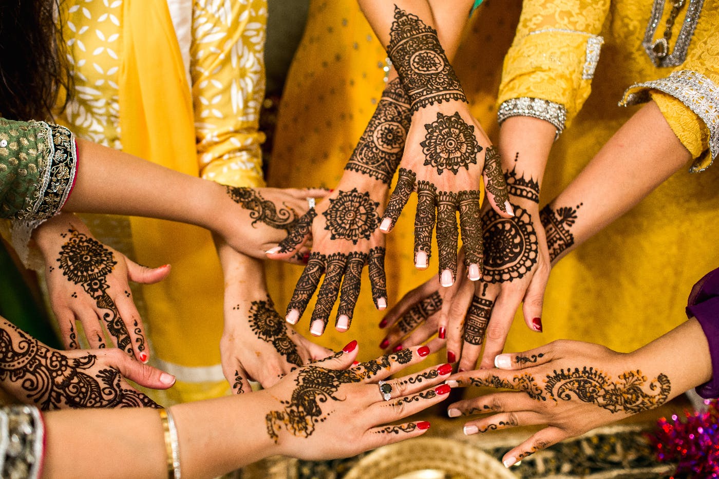 women showing their henna tattooed hands