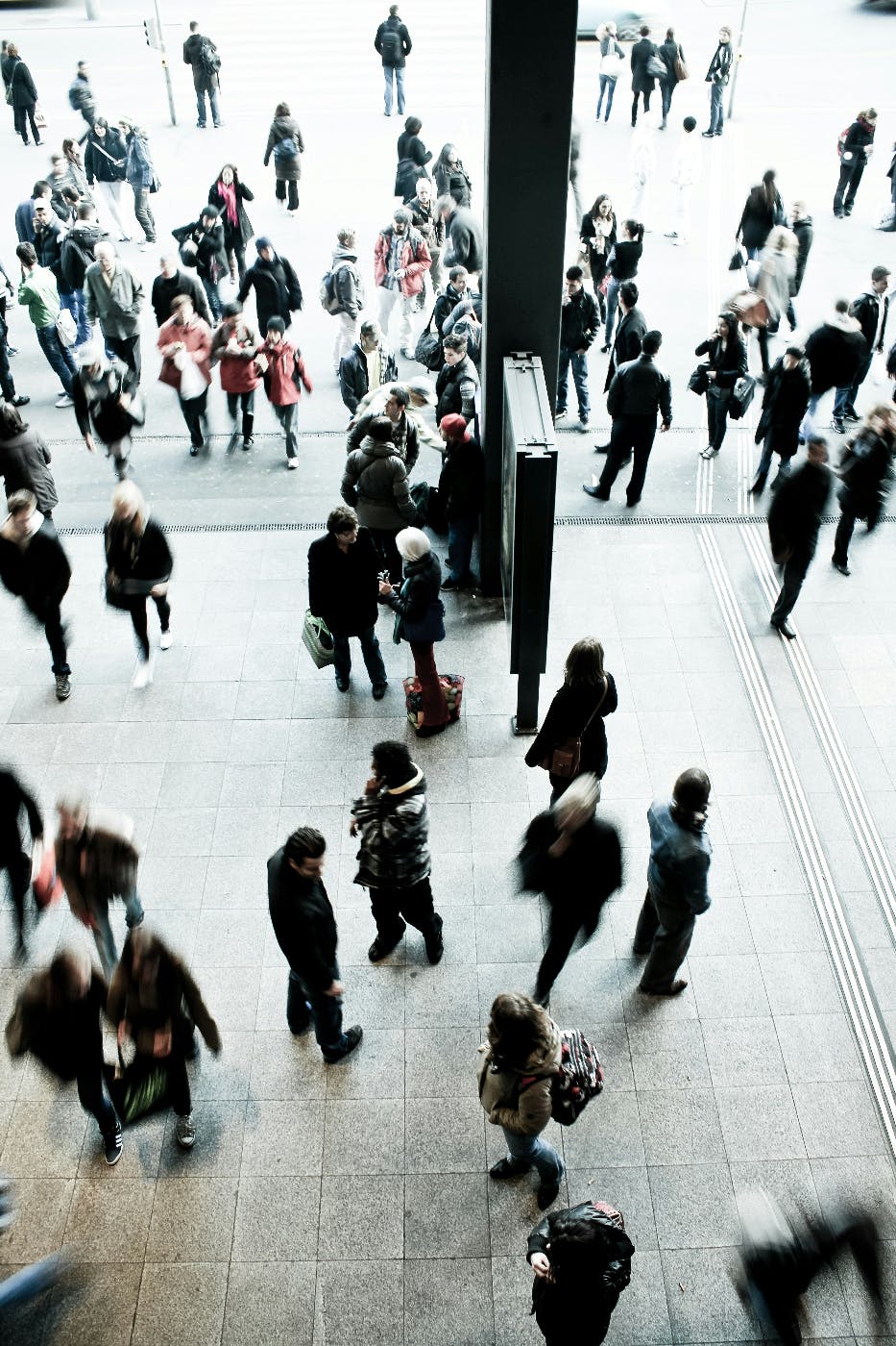 A crowd of people moving in and away from a subway entrance