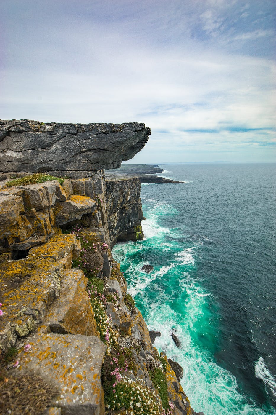 A terrifying cliff overhanging a rocky shoreline