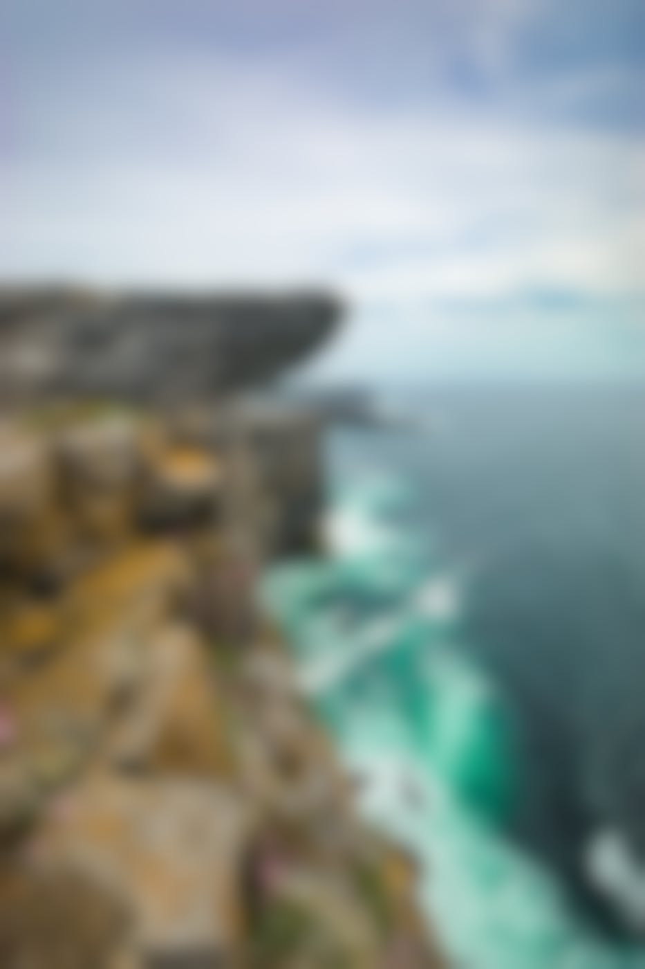 A terrifying cliff overhanging a rocky shoreline