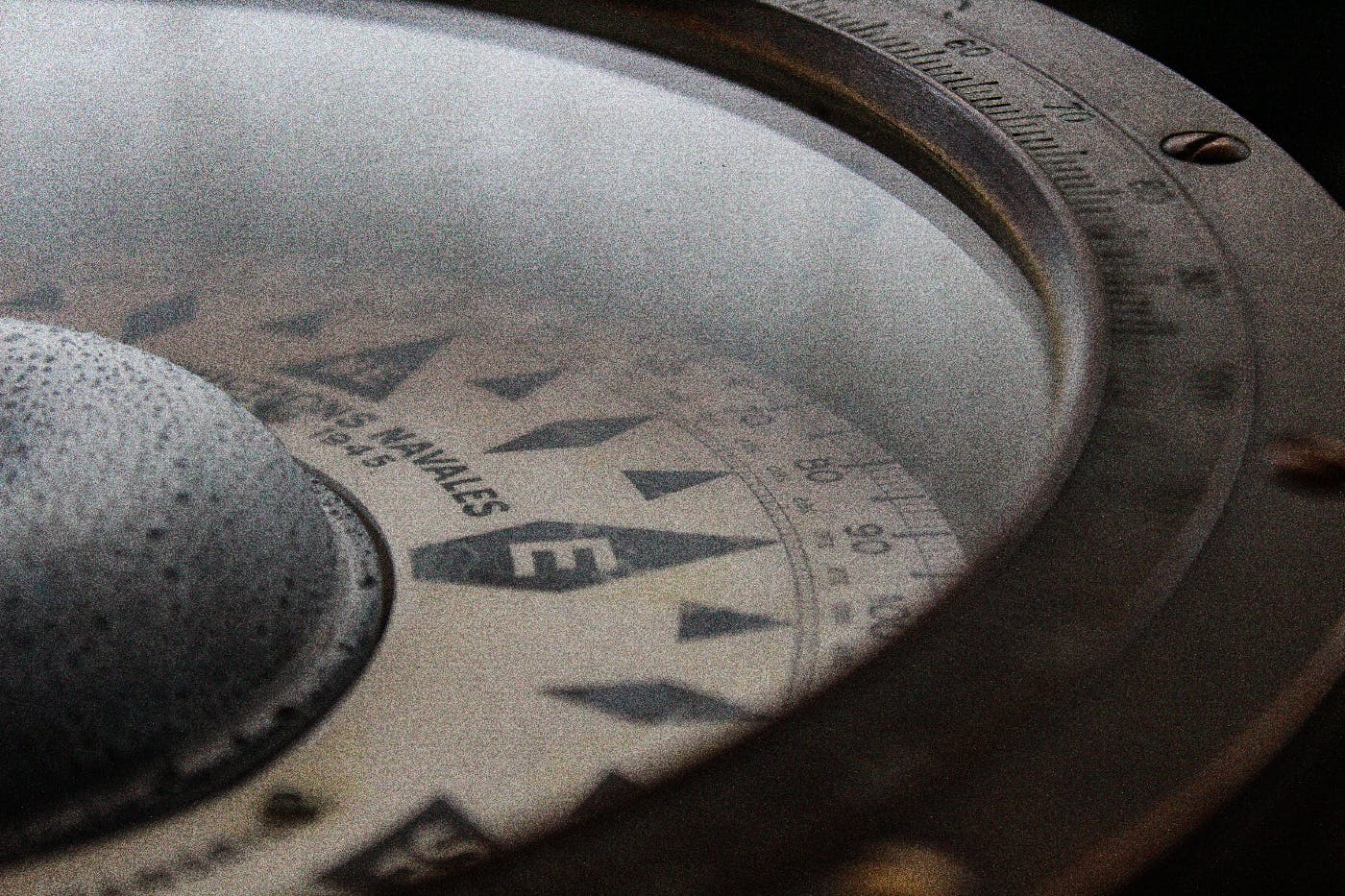 a close up of a compass pointing east