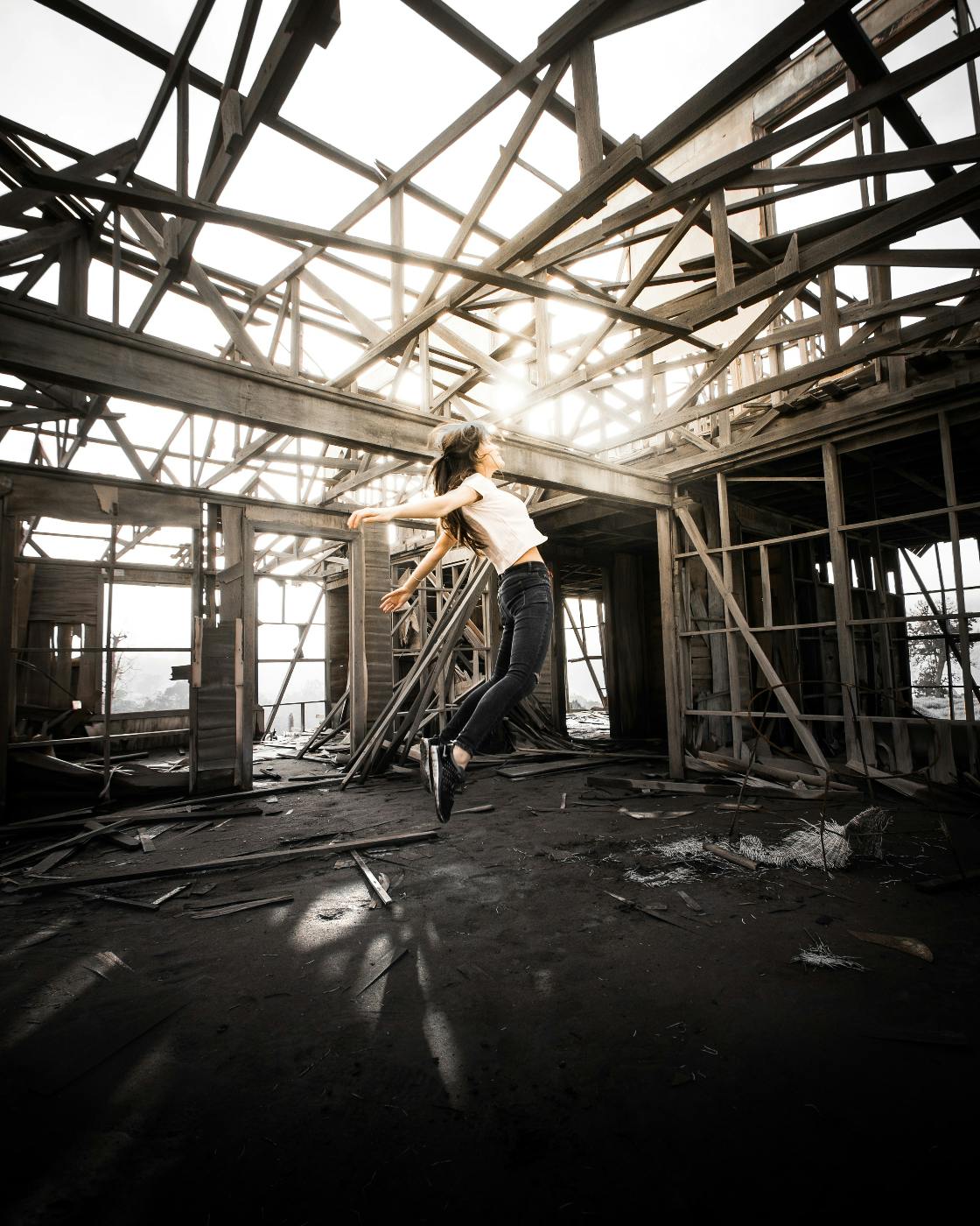 A woman leaping in an unfinished house
