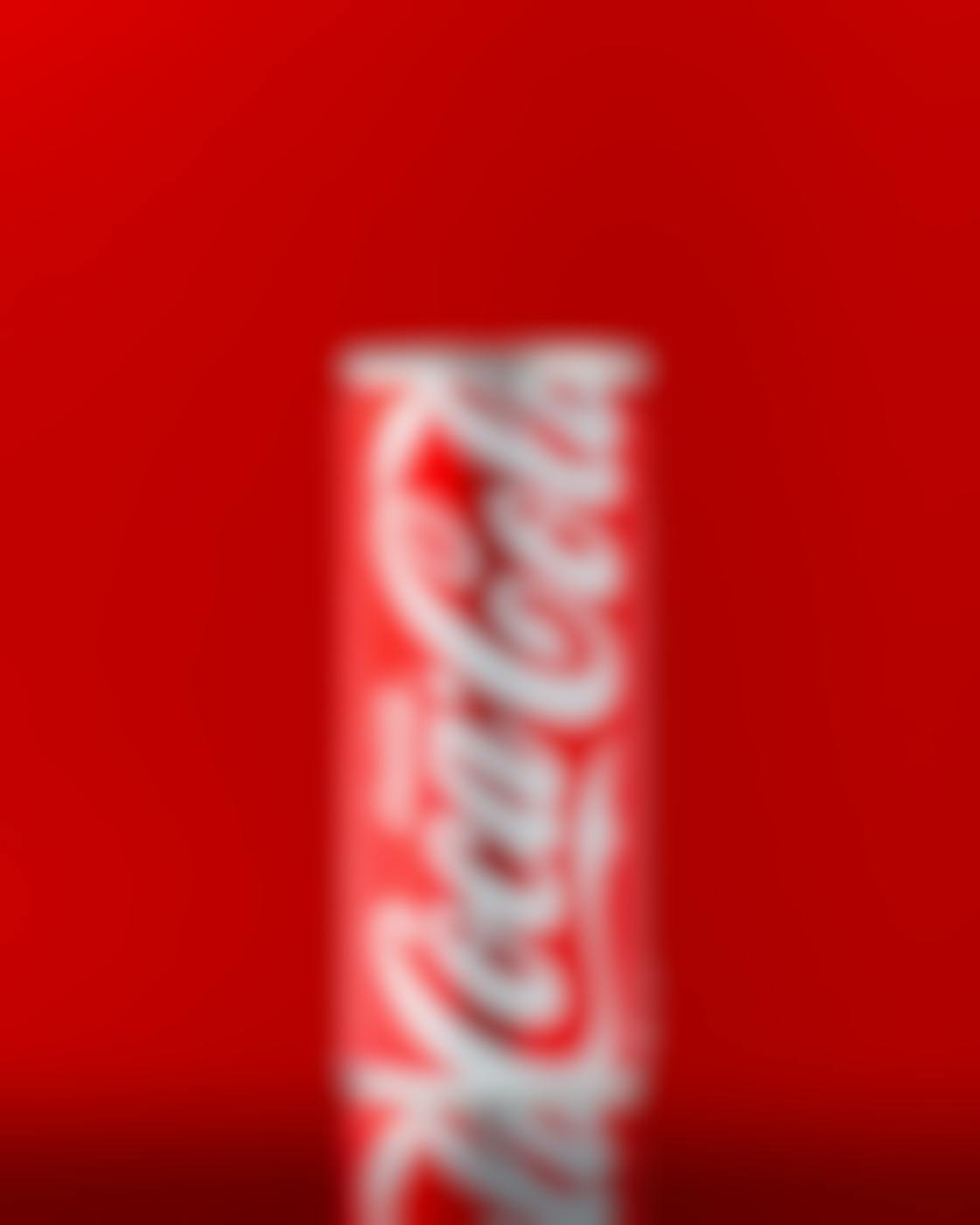 A slim can of Coca-Cola against a red background