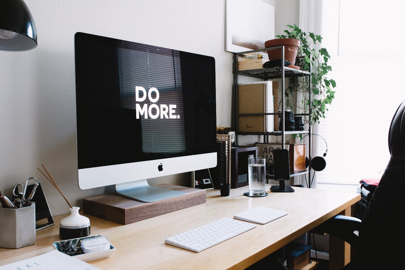 a desk with a huge montior dsiplaying the words Do More.